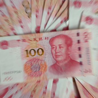 FILED - 12 December 2023, China, Beijing: Several bills, each with a value of 100 Chinese yuan, lie on a table. Photo: Johannes Neudecker/dpa Johannes Neudecker/dpa
