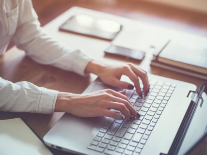 Recurso de una mujer escribiendo en un ordenador portátil. COMUNIDAD DE MADRID
