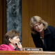 La senadora republicana Lisa Murkowski (en pie, a la derecha) y la demócrata Jeanne Shaheen (izquierda) conversan en una sesión del Senado de Estados Unidos Europa Press/Contacto/Stefani Reynolds - Pool Via