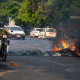 Un hombre conduce su motocicleta junto a neumáticos en llamas durante una manifestación contra el golpe militar y la detención de líderes civiles en Yangon, Birmania. Theint Mon Soe/SOPA Images via Z / DPA