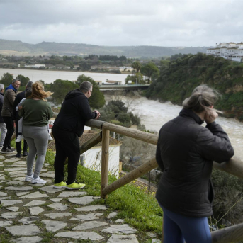 Algunos vecinos en Arcos observan desde una zona alta el caudal por el desembalse en la presa. Joaquín Corchero - Europa Press
