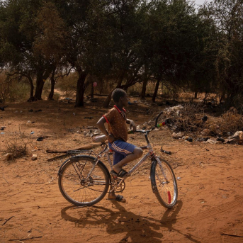Un niño con una bicicleta en un camino de la aldea de Ganguel, a 11 de enero de 2023, en Ganguel, Sokoto, Níger (África). David Zorrakino - Europa Press