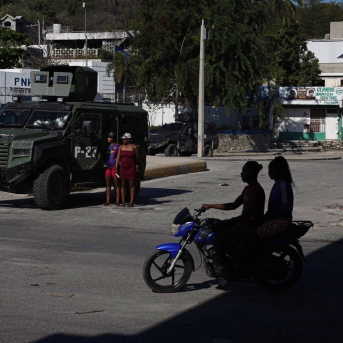 Un vehículo blindado de las fuerzas de seguridad y algunos transeúntes cerca de la intersección del aeropuerto, mejor conocida como la intersección de Rezistans, en Puerto Príncipe, capital de Haití Europa Press/Contacto/David Allignon