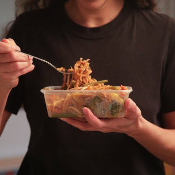 Chica comiendo un plato preparado de espagueti. GREENPEACE