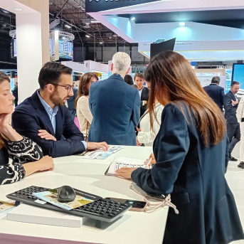 Una pareja recibe información de la oferta de Aedas Homes en el SIMA. AEDAS HOMES