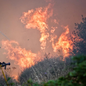 Un bombero trata de apagar el fuego, a 21 de agosto de 2025, en Anllarinos del Sil (León). Xuan Cueto - Europa Press