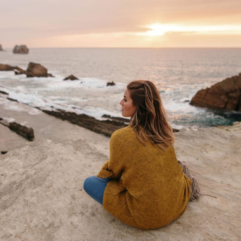 Mujer joven sentada junto al mar MARIOGUTI