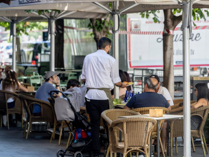 Un camarero atendiendo la terraza de un bar en la temporada de verano Ricardo Rubio - Europa Press