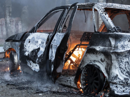 El coche en llamas en el lugar del ataque aéreo, provocado por una bomba guiada que impactó justo al lado de una pequeña tienda de comestibles de barrio. Europa Press/Contacto/Natasha Rudenko