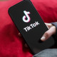 A girl holds an iPhone 16 with the logo of the TikTok app on it.  Jan Woitas/dpa