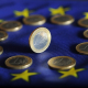 Monedas de euro sobre una bandera europea. picture alliance / Uli Deck/dpa