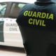 Un agente de la Guardia Civil junto a un vehículo oficial. GUARDIA CIVIL