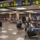 Varias personas esperan sentadas con sus maletas en el Aeropuerto Josep Tarradellas Barcelona-El Prat.  Lorena Sopêna - Europa Press