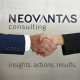 Dos personas se estrechan la mano frente al logo de Neovantas. NEOVANTAS
