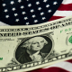 FILED - 14 July 2011, Dresden: A US One Dollar is pictured on a US flag. Photo: Arno Burgi/dpa-Zentralbild/dpa Arno Burgi/dpa-Zentralbild/dpa