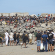 Miembros de la Cruz Roja reparten comida a los inmigrantes en una playa, a 21 de agosto de 2026, en Ceuta (España).  Marcos Moreno - Europa Press