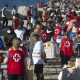 Miembros de la Cruz Roja reparten comida a los inmigrantes en una playa, a 21 de agosto de 2026, en Ceuta (España).  Marcos Moreno - Europa Press