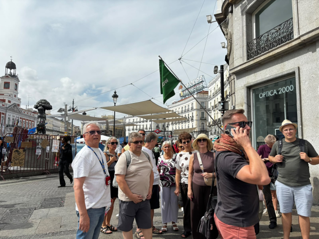 Un grupo de turistas se encuentra en la Puerta del Sol con su guía | L.G. Un grupo de turistas se encuentra en la Puerta del Sol con su guía | L.G.