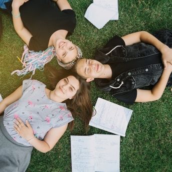 jovenes-estudiantes-acostado-en-el-cesped jovenes-estudiantes-acostado-en-el-cesped