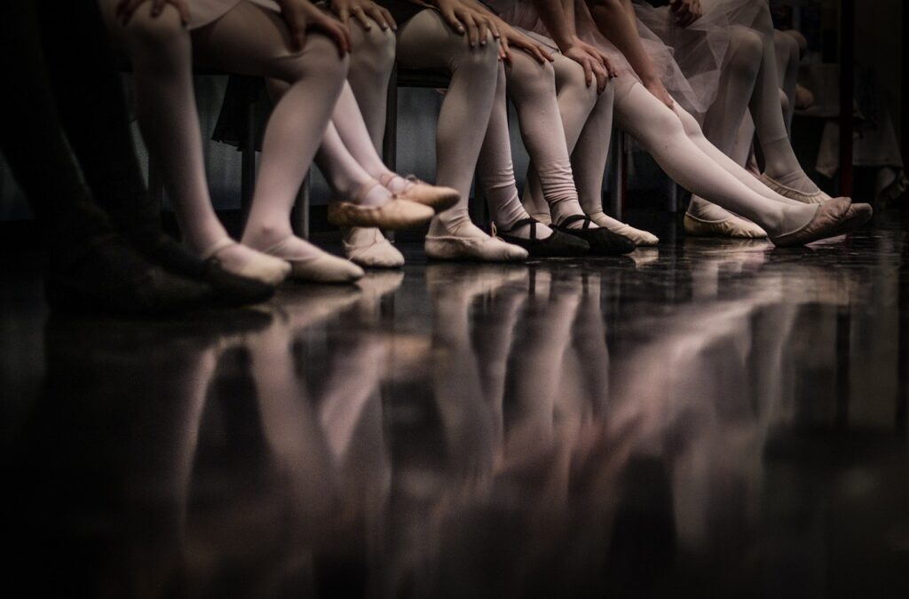 Imagen de unas bailarinas de ballet descansando sobre un banco. Fuente Pixabay.
