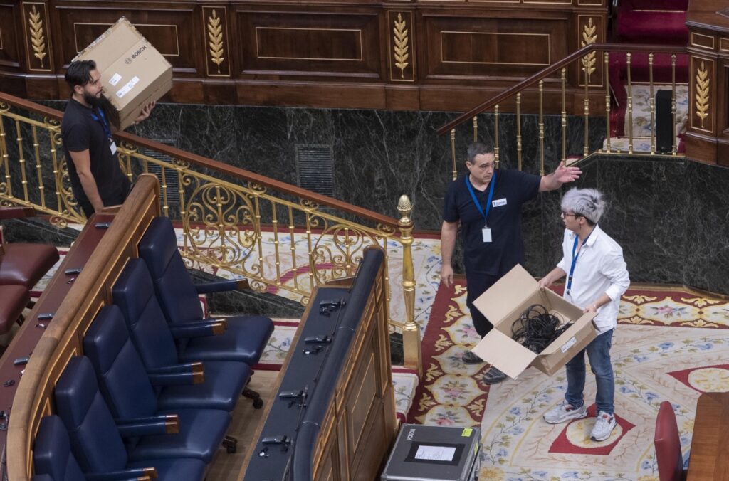 Varios técnicos preparan los pinganillos para que los diputados puedan recibir la traducción simultánea de las lenguas cooficiales antes de la primera sesión del debate de investidura del líder del PP, en el Congreso de los Diputados. Fuente Alberto Ortega / Europa Press