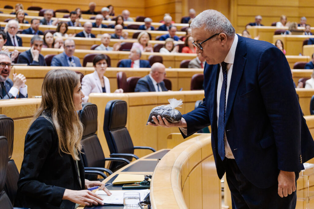 El senador del PP, Francisco Bernabé Pérez, entrega a la vicepresidenta tercera y ministra para la Transición Ecológica, Sara Aagesen, un paquete con tierra contaminada durante una sesión de control al Gobierno, en el Senado