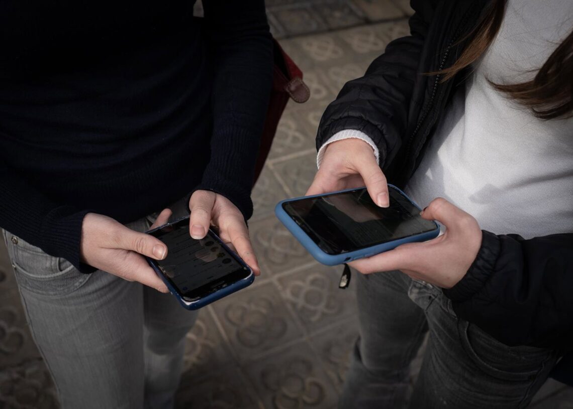 Archivo - Dos personas usan el teléfono móvil.David Zorrakino - Europa Press - Archivo