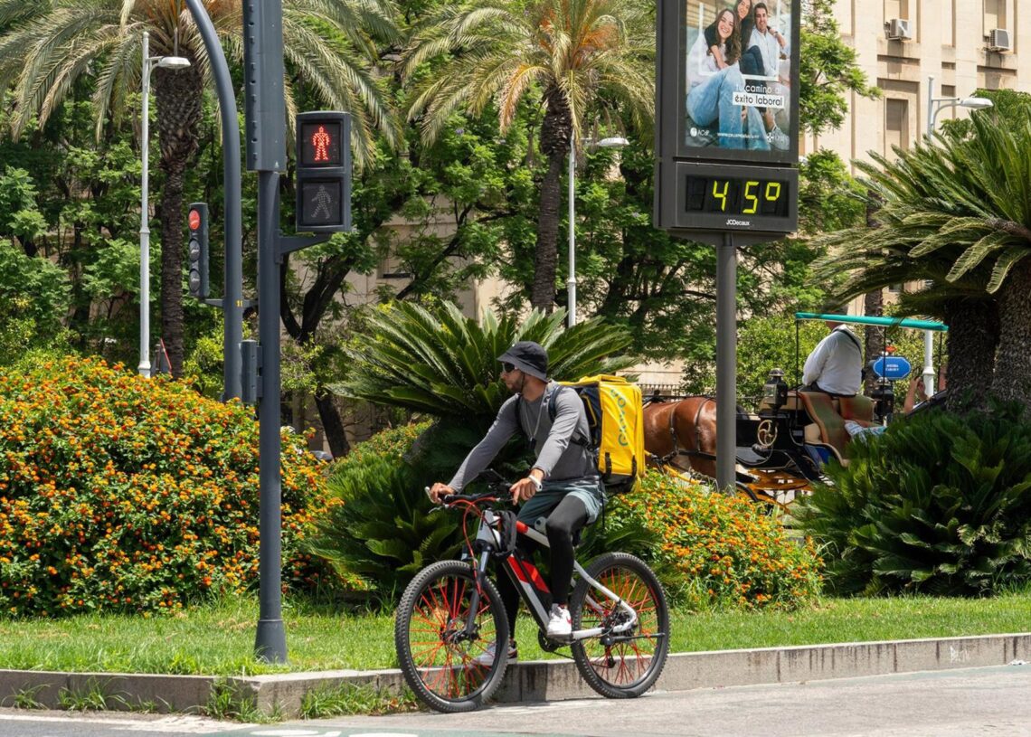Archivo - Un termómetro marca 45 grados a las 14:00 de la tarde junto a un trabajador de Glovo en bicicleta, a 19 de julio de 2024, en Sevilla, Andalucía (España).Francisco J. Olmo - Europa Press - Archivo