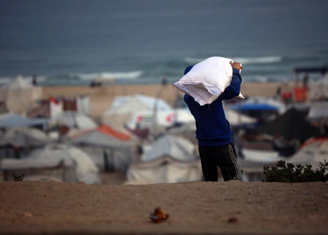 Archivo - Imagen de archivo de palestinos cargando sacos de harina proporcionados por caiones con ayuda humanitaria en ciudad de GazaEuropa Press/Contacto/Omar Ashtawy - Archivo
