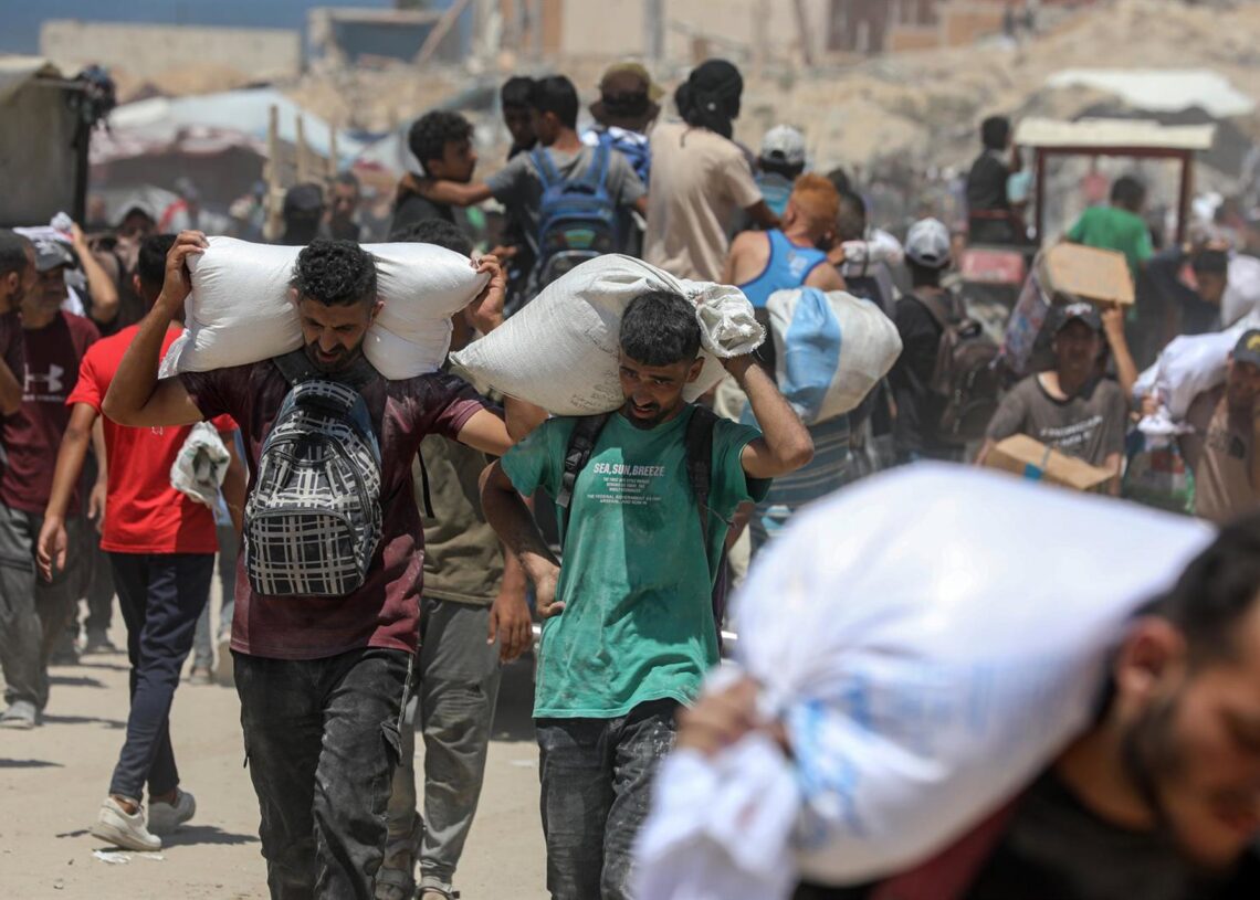 Archivo - Palestinos transportan sacos de harina que obtuvieron de camiones de ayuda humanitaria que entraron en Gaza a través del paso fronterizo de Zikim, en Yabalia, en el norte de la Franja de GazaEuropa Press/Contacto/Omar Ashtawy