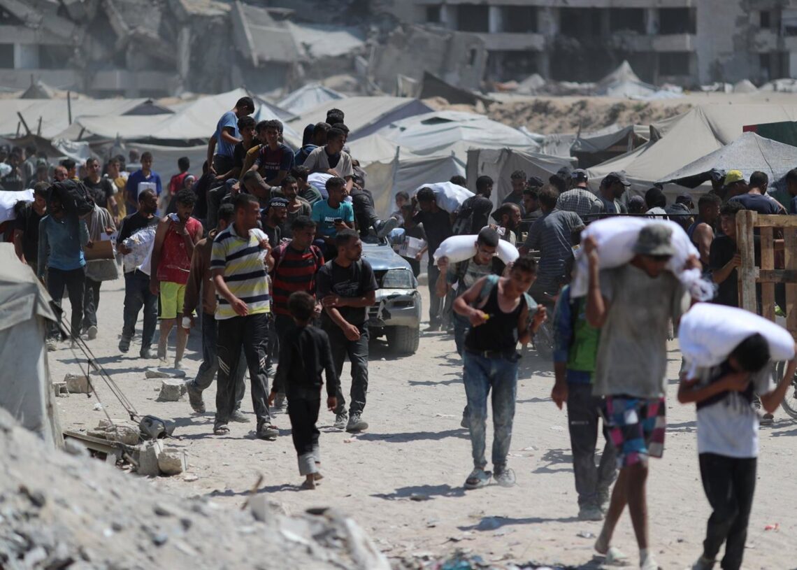 07 August 2025, Palestinian Territories, Gaza City: Palestinians carry aid supplies which they received from the U.S.-backed Gaza Humanitarian Foundation (GHF). Photo: Omar Ashtawy/APA Images via ZUMA Press Wire/dpaOmar Ashtawy/APA Images via ZUMA / DPA