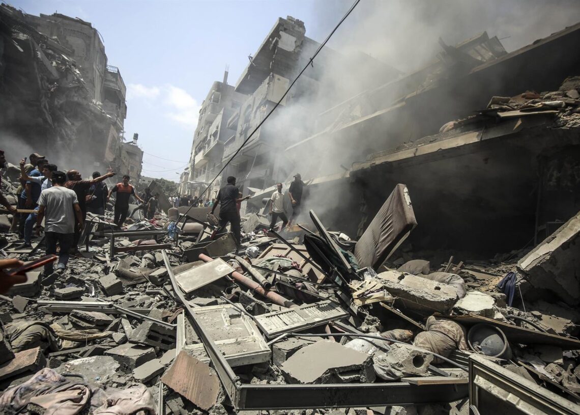 Un grupo de civiles camina entre los escombros de un edificio en ciudad de GazaOmar Ashtawy/APA Images via ZUMA / DPA