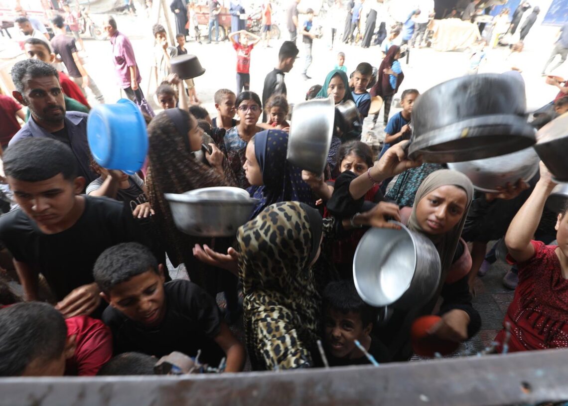 Un grupo de palestinos esperan para recibir comida en Bureij, en el centro de la Franja de GazaMoiz Salhi / Zuma Press / ContactoPhoto