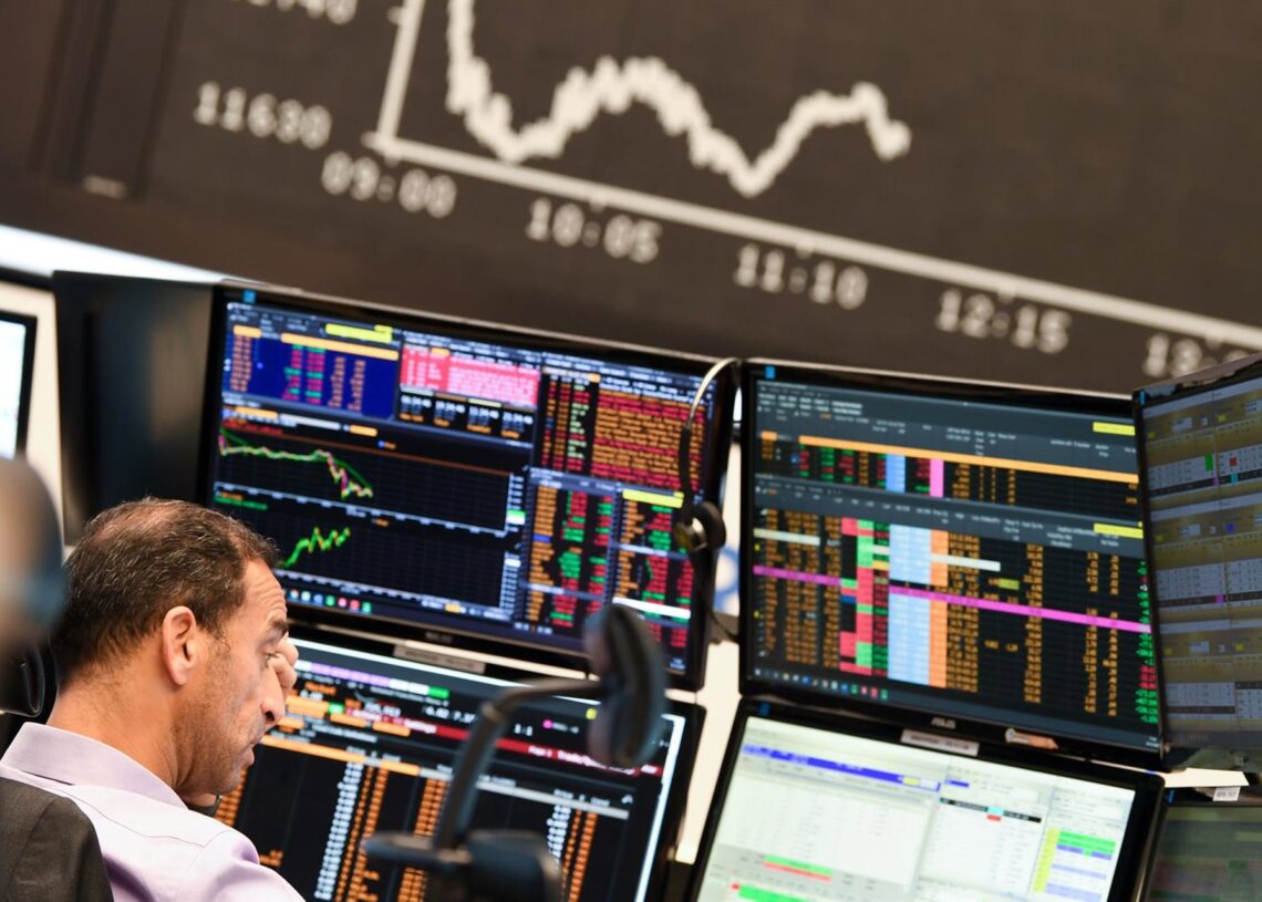 Archivo - 28 October 2020, Hessen, Frankfurt/Main: A stock trader observes his monitors on the floor of the Frankfurt Stock Exchange in front of the board with the falling Dax curve. Photo: Arne Dedert/dpaArne Dedert/dpa - Archivo