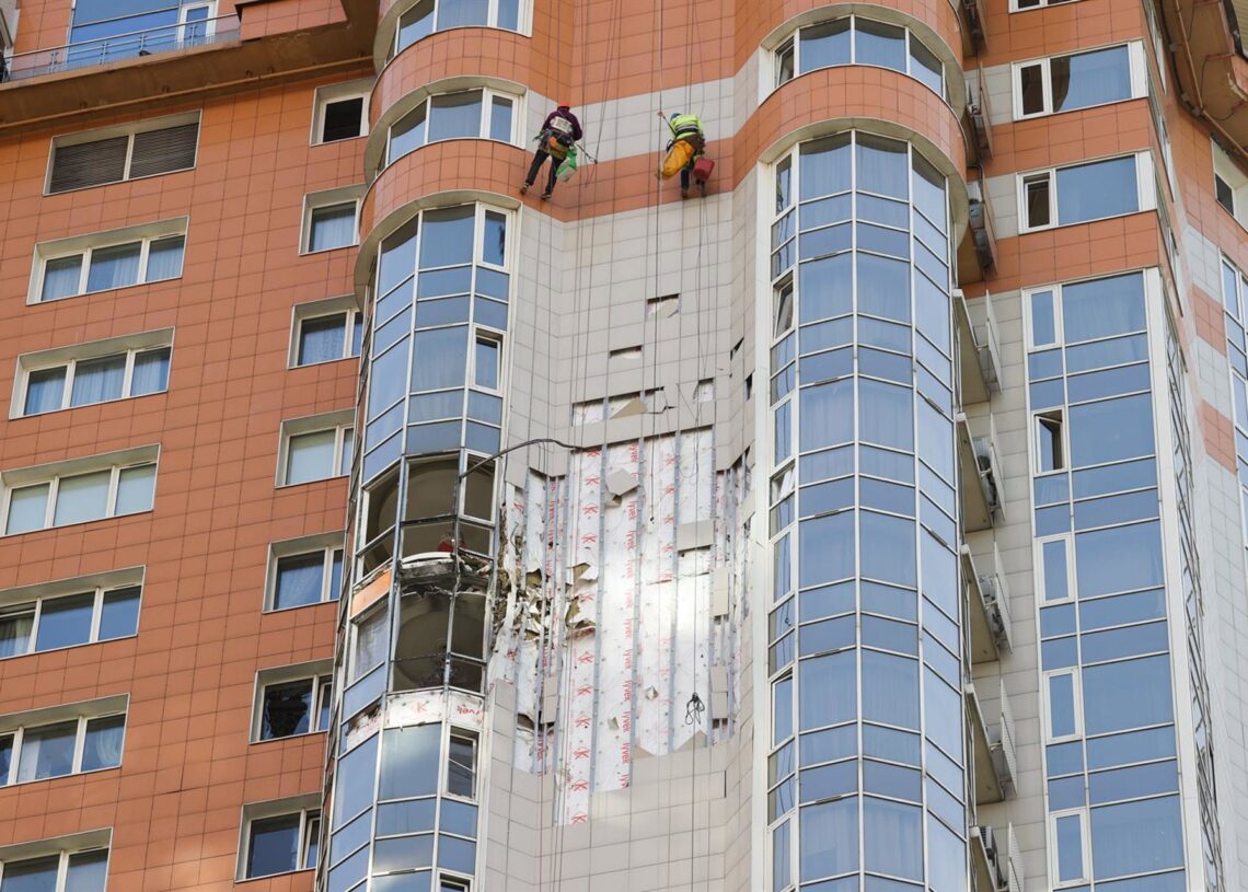 Archivo - Imagen de archivo de dos trabajadores reparando varias ventanas en un edificio alcanzado por un dron ucraniano en Moscú.Europa Press/Contacto/Valeria Kalugina - Archivo