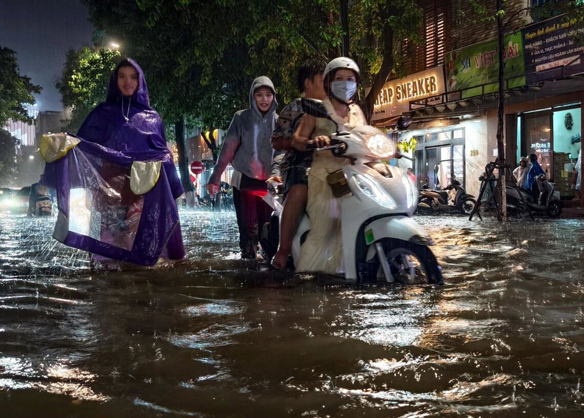 Archivo - Imagen de archivo de varias personas atravesando una calle anegada de Vietnam.Europa Press/Contacto/Pavel Karavashkin - Archivo