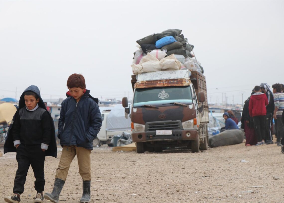 Archivo - Dos niños caminan mientras a su espalda se prepara un convoy de personas para abandonar el campo de Al Hol, en la provincia siria de Hasaka, en el noreste del país Europa Press/Contacto/Stringer - Archivo