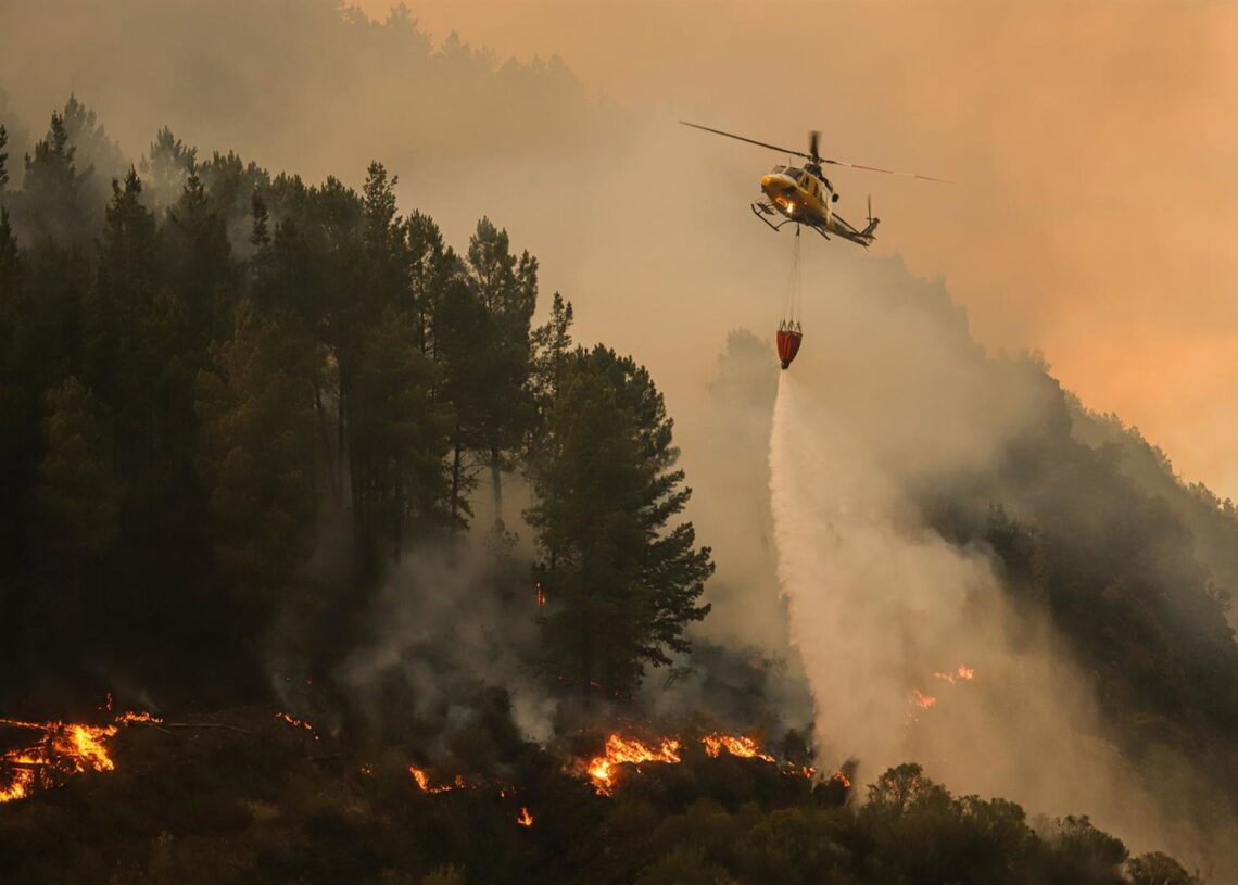 Un helicóptero suelta agua sobre el fuego.Adrián Irago - Europa Press