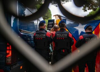 Archivo - Mossos d' escuadra detrás de la bandera estelada, y de activistas, durante la concentración convocada por la ANC en contra de la sentencia que obliga a la Generalitat a devolver las pinturas de Sijena, a 28 de julio de 2025, en Barcelona (EspañaLorena Sopêna - Europa Press - Archivo