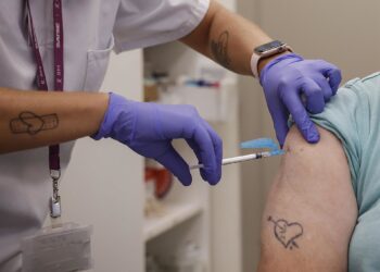 Archivo - Imagen de archivo de una mujer vacunándose durante el inicio de la campaña de vacunación frente a la gripe y la Covid-19 en España.Rober Solsona - Europa Press - Archivo