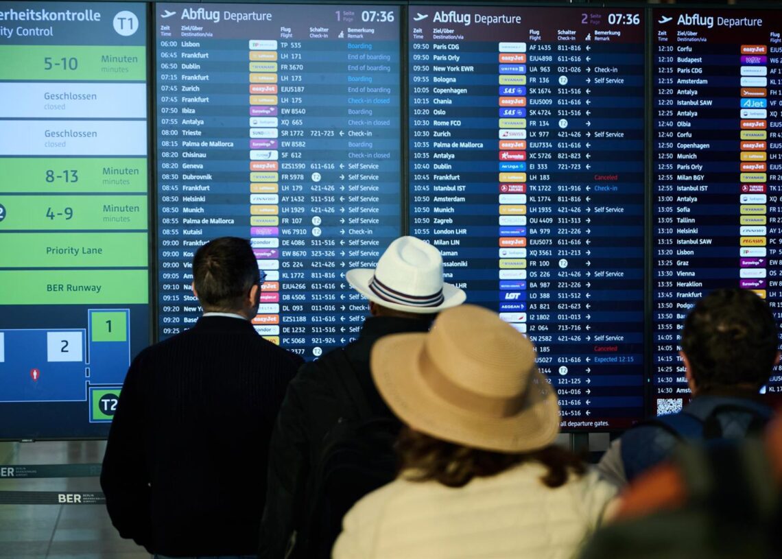 28 September 2025, Brandenburg, Schoenefeld: People stand at BER Airport and look at the departure board. Annette Riedl/dpa