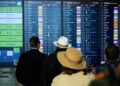 28 September 2025, Brandenburg, Schoenefeld: People stand at BER Airport and look at the departure board. Annette Riedl/dpa