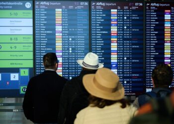 28 September 2025, Brandenburg, Schoenefeld: People stand at BER Airport and look at the departure board. Annette Riedl/dpa
