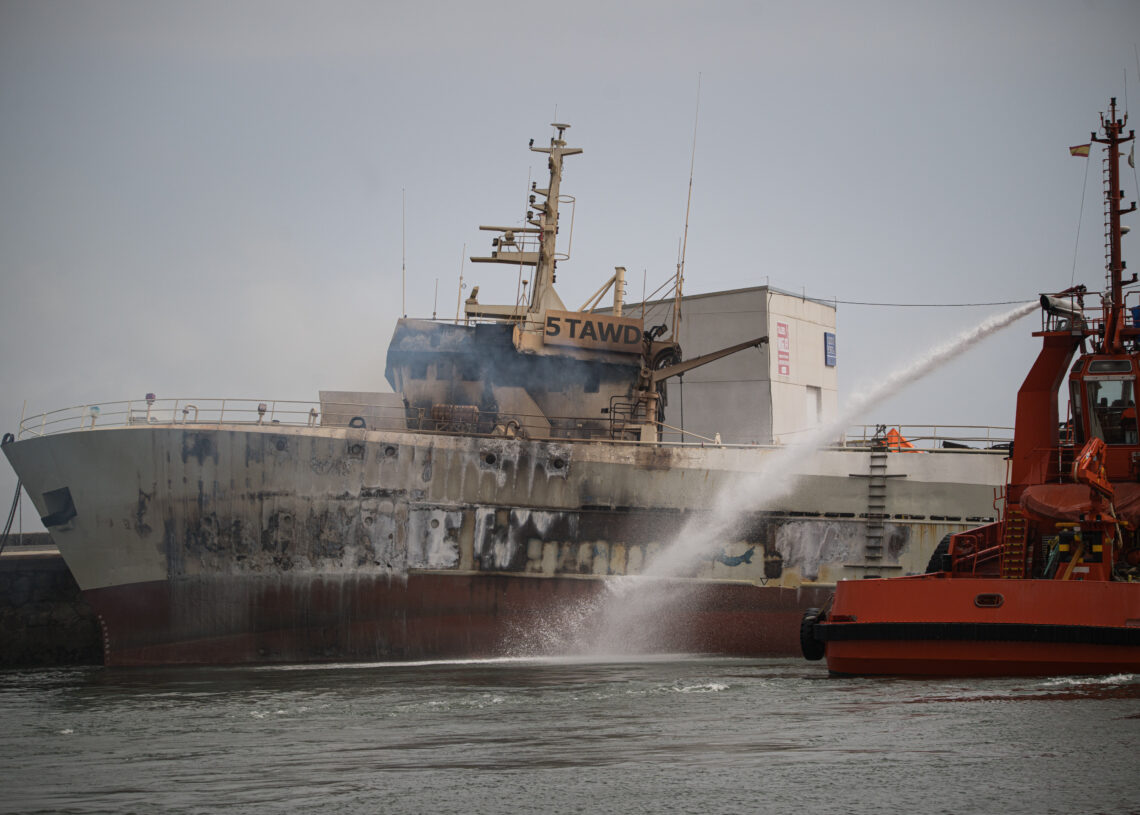 Agentes de los Servicios de Emergencias trabajan por apagar el incendio del buque Awadi, en el puerto de Ribeira, a 2 de septiembre de 2025, en Ribeira, A Coruña, Galicia (España).