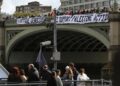 Un grupo de activistas sostiene dos pancartas en el lateral del puente de Westminster con el lema "Me opongo al Genocidio y Apoyo la Acción Palestina" durante un acto de protesta, rodeados de policías, en Londres, Reino UnidoEuropa Press/Contacto/Martin Pope