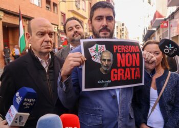 El portavoz de Vox en las Cortes, Alejandro Nolasco, sostiene un cartel con el que insta a declarar persona non grata al portavoz y fundador de la Casa Palestina de Aragón, Ibrahim Abayat, en una comparecencia frente a la sede de Casa Palestina.VOX