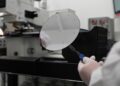 Archivo - FILED - 26 August 2025, Hamburg: An employee of Nexperia Germany GmbH holds an intermediate product of semiconductor production, a so-called wafer, with tweezers on the premises of semiconductor manufacturer Nexperia. Photo: David Hammersen/dpaDavid Hammersen/dpa - Archivo