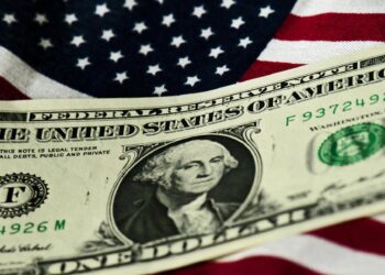 Archivo - Billete de dólar sobre una bandera de Estados Unidos (EE.UU.).Arno Burgi/dpa-Zentralbild/dpa - Archivo