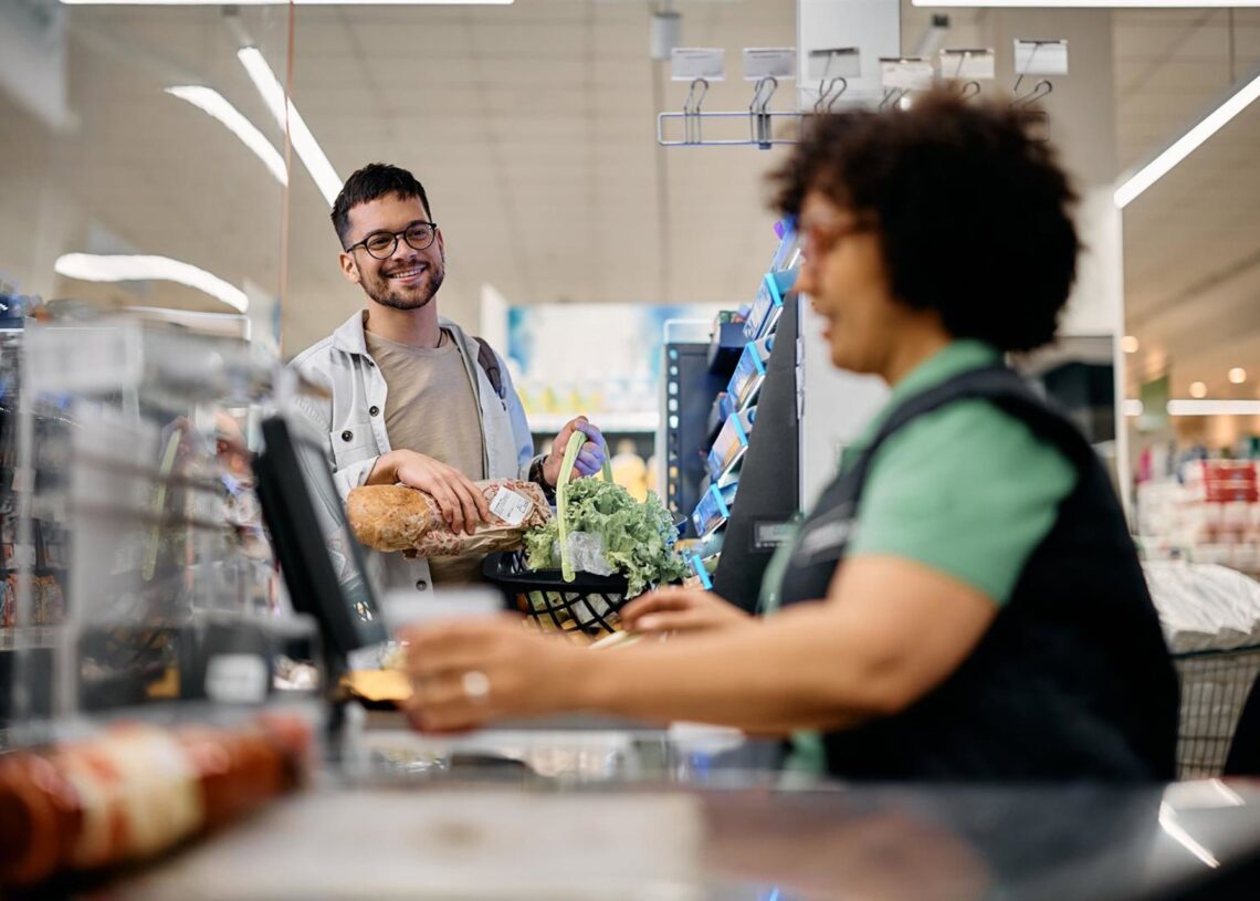 Archivo - Hombre pasando por la caja de un supermercado.GELT - Archivo