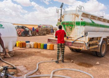 Archivo - Un camionero entregando agua a las personas desplazadas en el campo de desplazados internos de Galidle, en Somalia.OXFAM INTERMÓN - Archivo